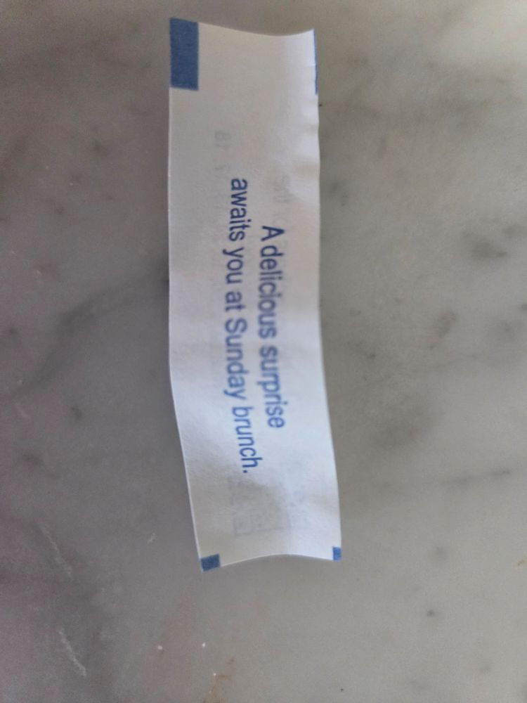 Fortune cookie slip that says "A delicious surprise awaits you at Sunday brunch."