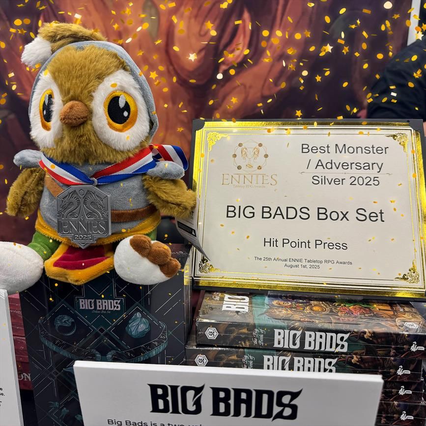 A Riffin plush sits next to a stack of Big Bads box sets at our Gen Con booth this past weekend. He's wearing a silver ENNIE Award medal that we received for Big Bads!