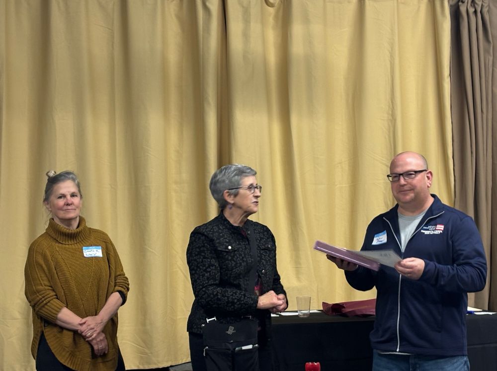 Three people looking at a book