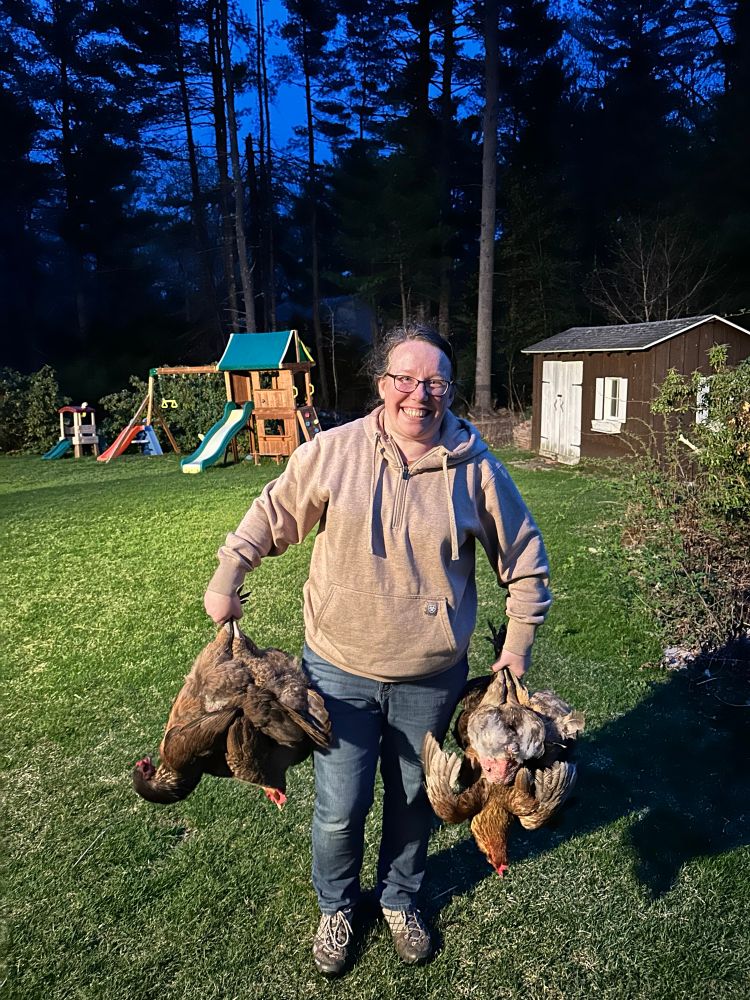 Mrs Newman holding a small flock of chickens by the feet.