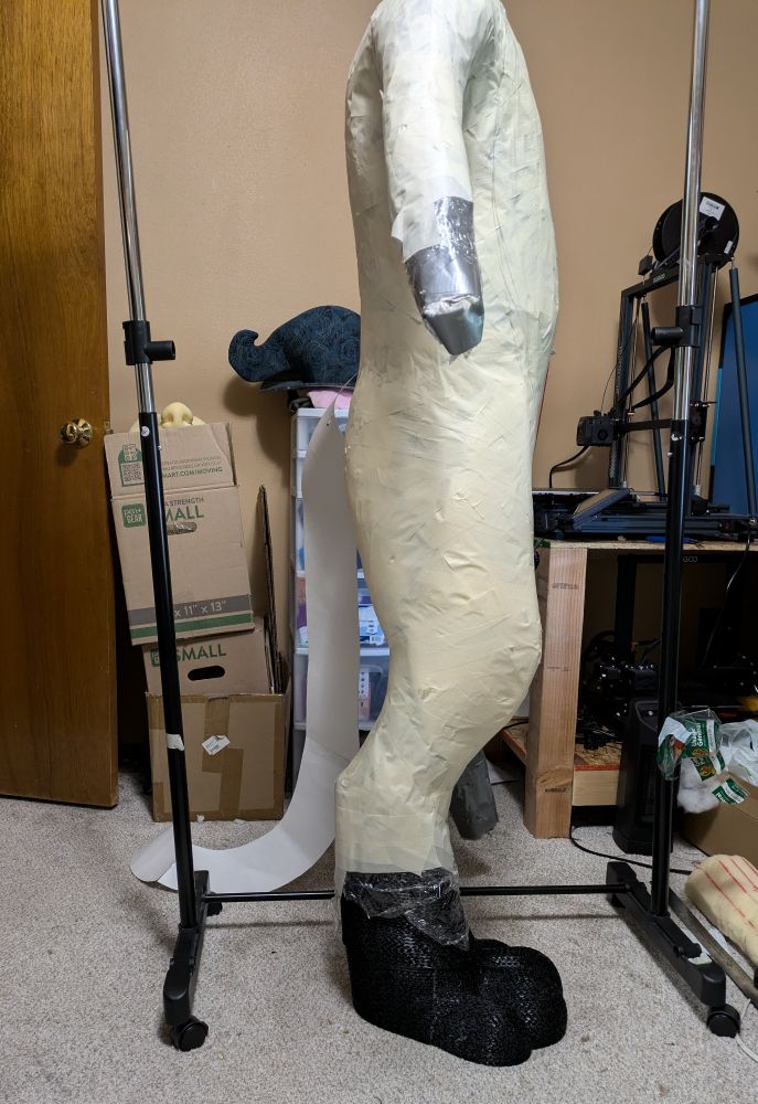 Duct tape dummy with foam padding on legs with TPU printed boot tapped up for Fursuit patterning 