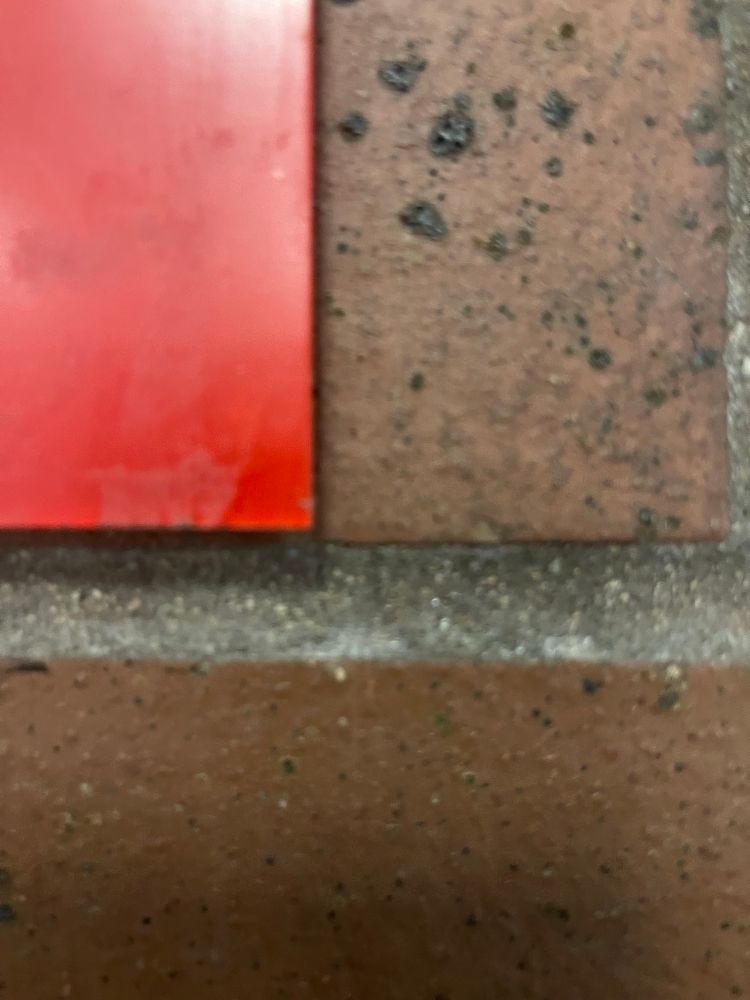 Close up of bricks with corner of a bright red sign on the left (my view at the elevator)
