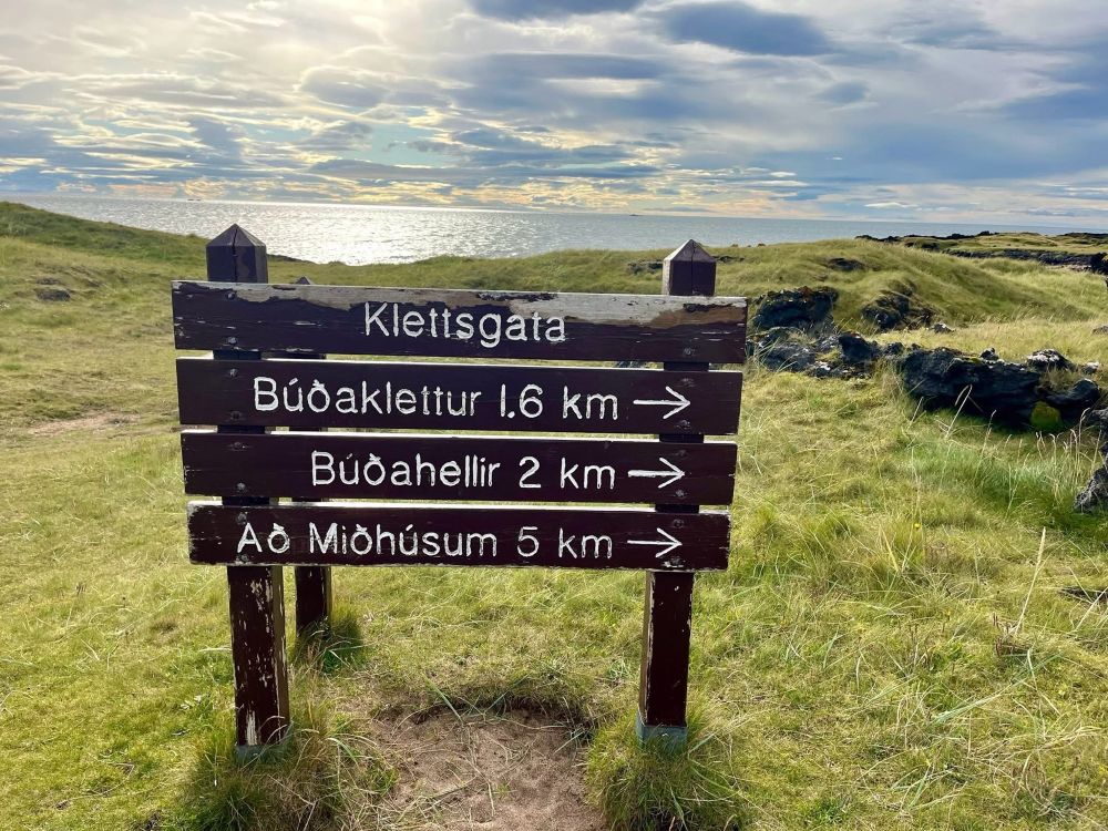 A road sign written in Icelandic (maybe?) posted before a beautiful view that I am sure is actually Icelandic. 