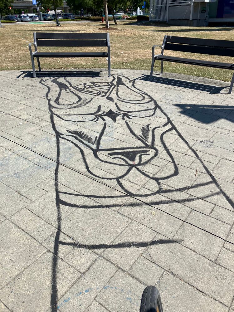 Graffiti of dog’s head on slabs near Carrall St, Vancouver