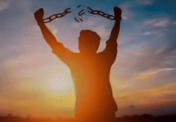 a silhouette of a man holding a broken chain in his hands .