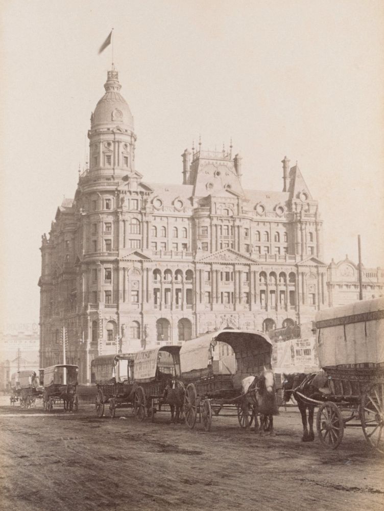 The "Federal Coffee Palace" in front of a line of horse-pulled wagons. It's a bloody big building. 