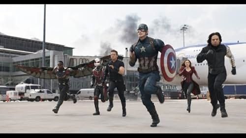 A group of superheroes is charging forward on an airport tarmac in a scene from Captain America: Civil War. From left to right, the characters are Falcon flying with mechanical wings, Ant-Man, Hawkeye, Captain America with his shield, Scarlet Witch, and Winter Soldier. In the background, there is an airplane, an airport terminal, smoke, and several vehicles.