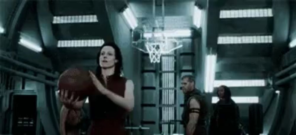 a woman holds a basketball in a dark room