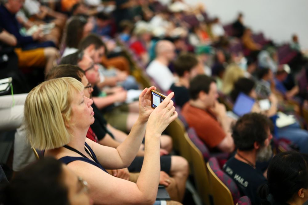 The crowd take their seats, a guest takes a photo