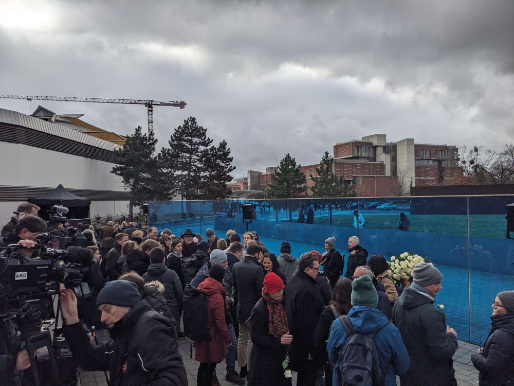 Viele Menschen vor einer blauen Wand.