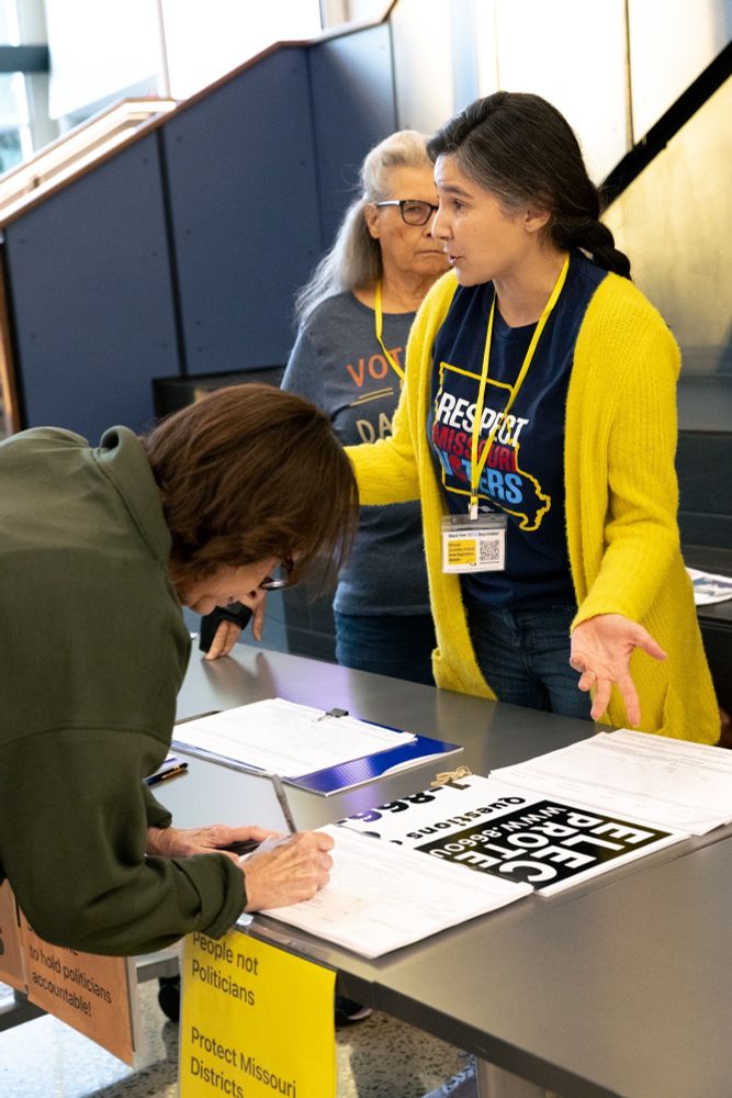 Volunteers talk to people signing the Respect MO Voters petition at the Women's Freedom Forum in Kansas City on October 7