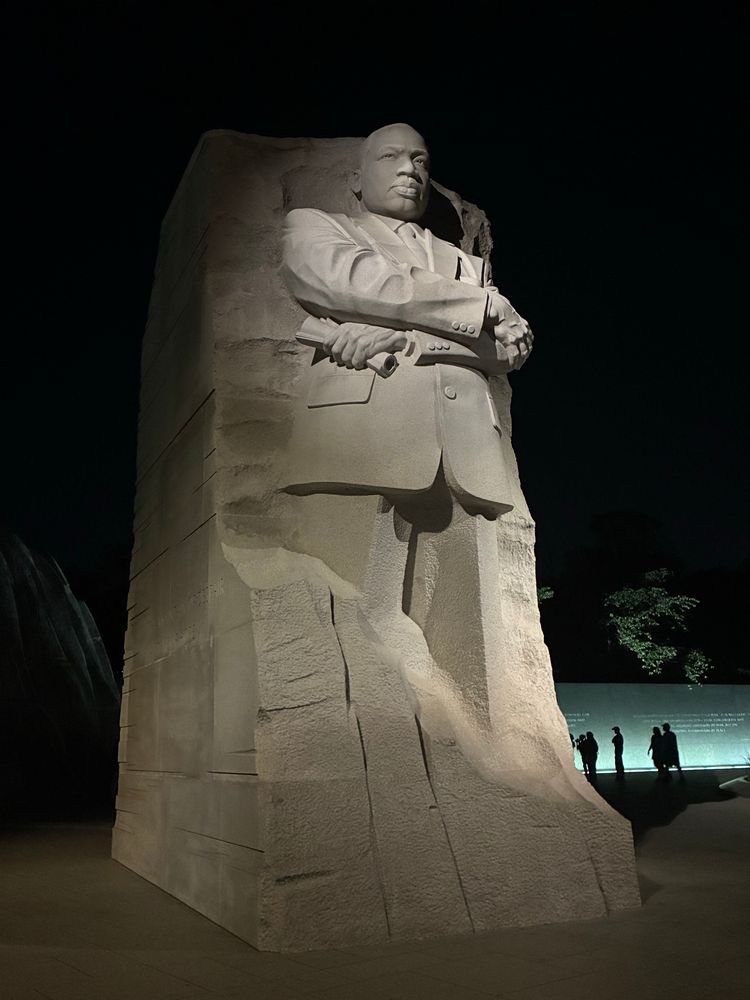 MLK memorial, dramatically lit at night, with King emerging from rough stone 