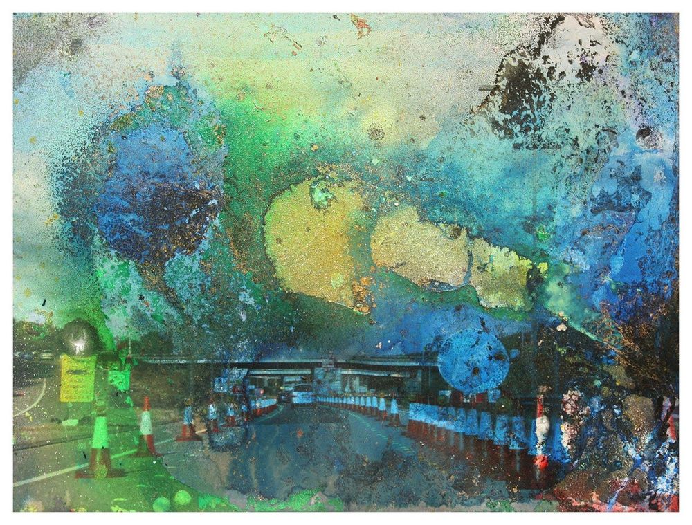 A photographic print of a motorway in England with lots of traffic cones.

Blue washes and Yellow hues, washes over the image, dashes of neon green.
reactions and incursions to the surface of the 35mm print from various chemicals and industrial paints.