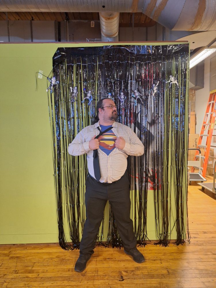 A guy dressed as Clark Kent opening his shirt revealing a Superman crest beneath