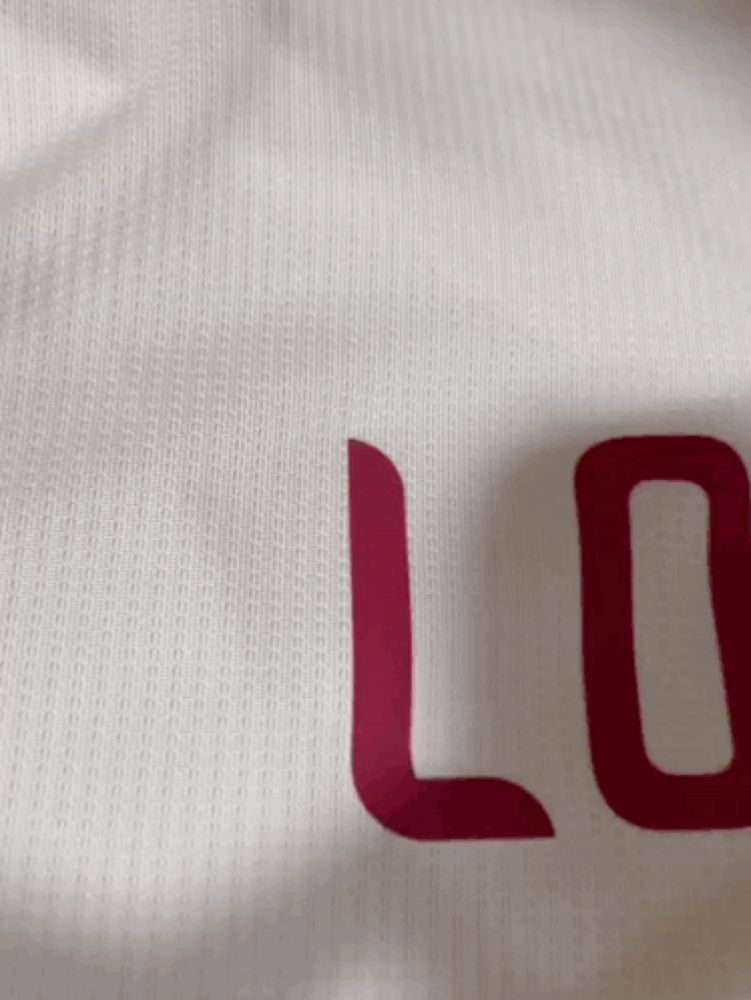 a close up of a white shirt with red letters that says lo