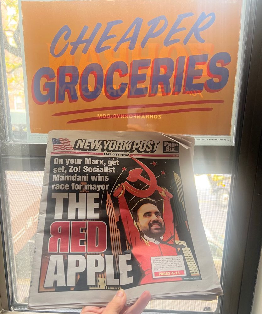 A photo of a Mamdani poster "Cheaper Groceries" and today's NYPost headline "On your Marx, get set, Zo! Socialist Mamdani wins race for mayor.