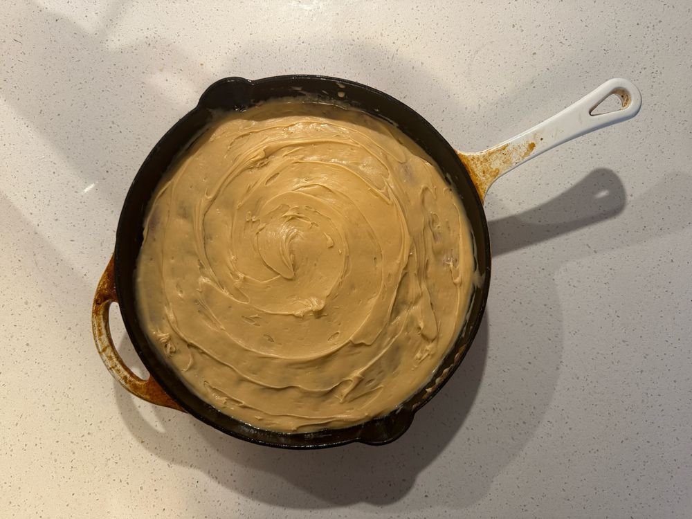 Apple cake with caramel icing in a cast iron skillet. 