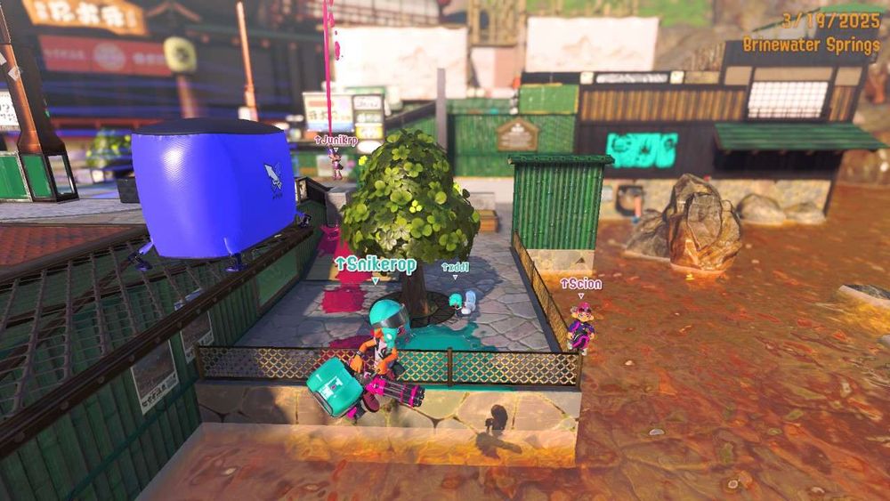 Picture of Upcurret on Brinewater Springs. In the middle stands a tree on the lowground area, and the team members are looking toward the camera situated over the water. From left to right is Snikerop (in mid air, falling into the water), Juni (far back and holding her H-3D into the air), xd (on the low ground next to the tree, charging their mint decavitator), and Scion (standing with a slosher on the corner of the low ground fence while waving).