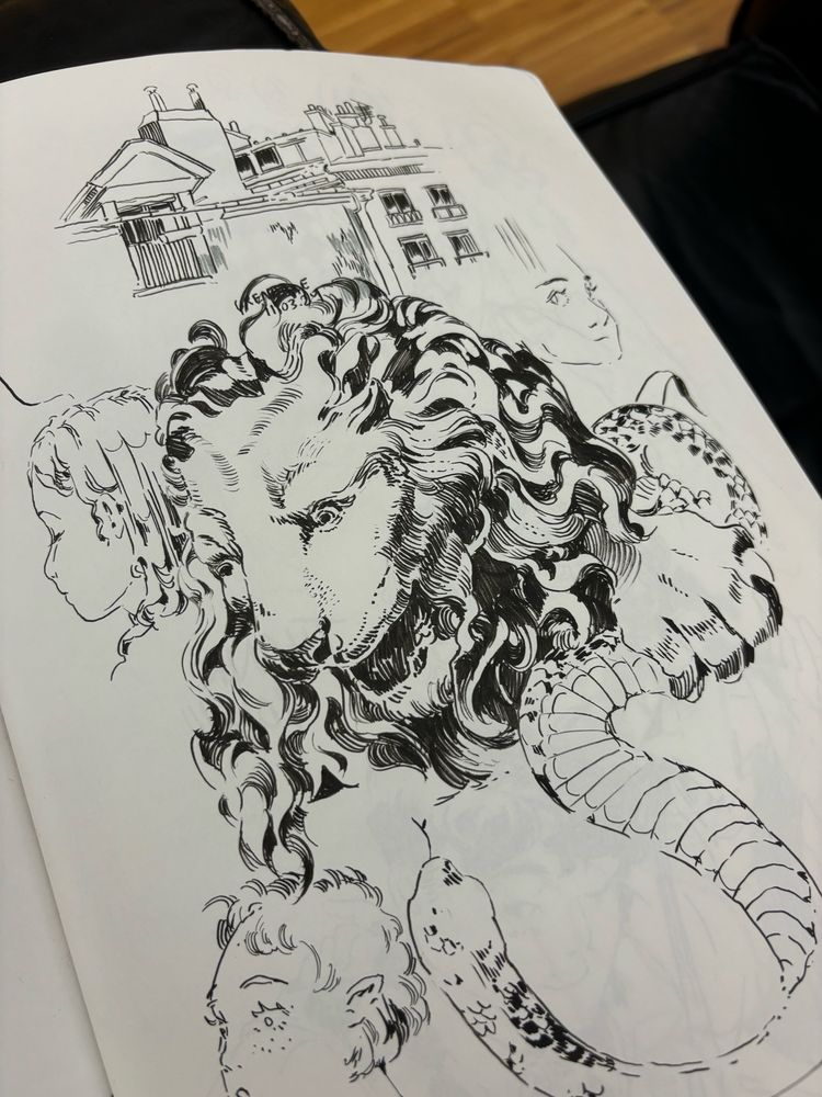Sketchbook page of ink drawings of a lion, snake, some buildings 