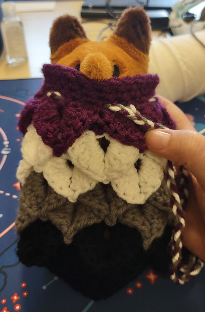 Same dice bag as described in previous photo, but a small fox plushie is snugly stuffed into it, only its head pops out the top.