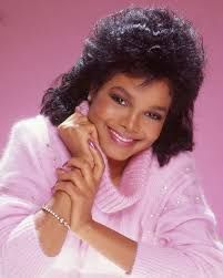 Janet Jackson with a perfect 80s bang & blowout and pink sweater