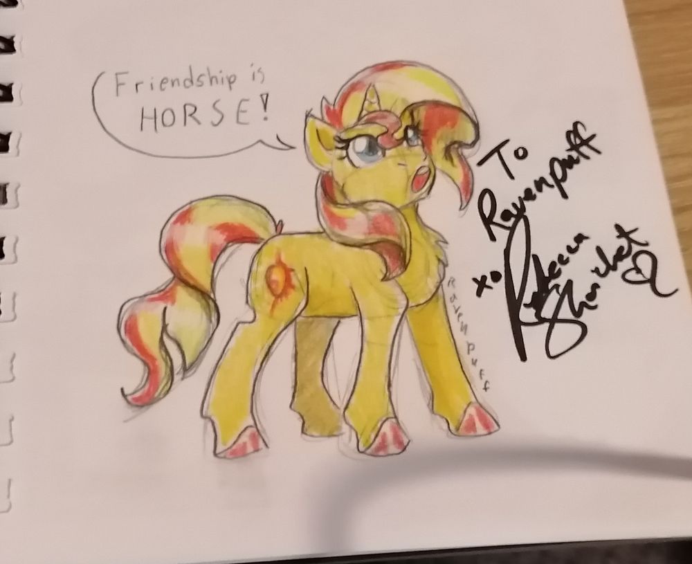 Photo of pencil sketch on paper with pencil colouring.

Pony form Sunset Shimmer looking upwards as she says "Friendship is HORSE!"

To her right is the signature of her VA, dedicated to Ravenpuff 