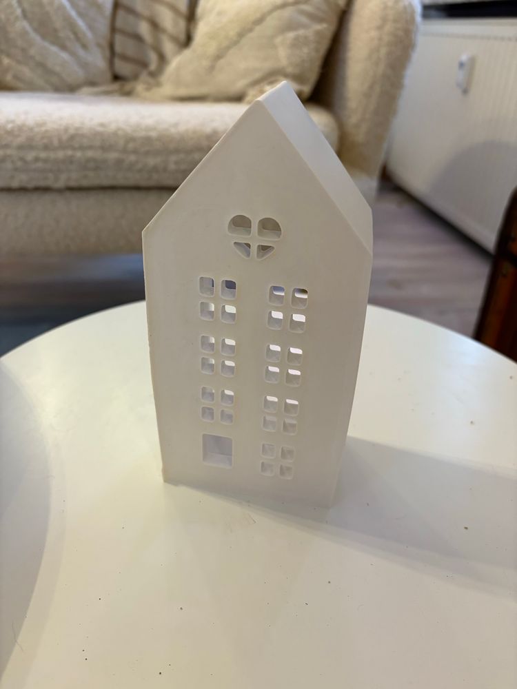 Ein weißes Häuschen mit Fenster Öffnungen aus Keramikgiessmasse 