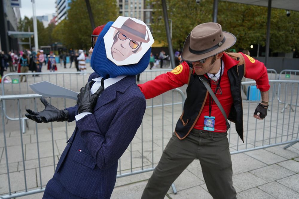 Team Fortress 2 cosplay photo of a Red Sniper stabbing a Blu Spy with a Kukri. The cycle of revenge will start anew on the next respawn 