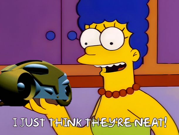 The character Marge Simpson from the animated television series "The Simpsons" holding a lightcycle from the 1982 film "Tron" with the caption "I just think they're neat!" underneath.
