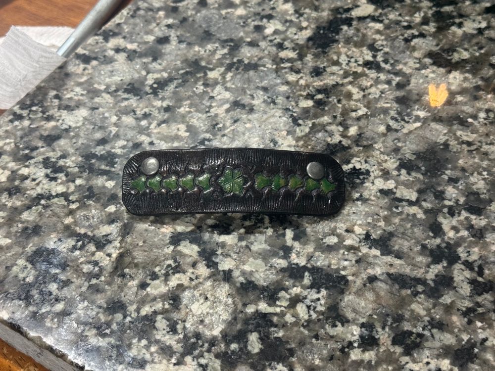 A handmade black and green leather hair clip