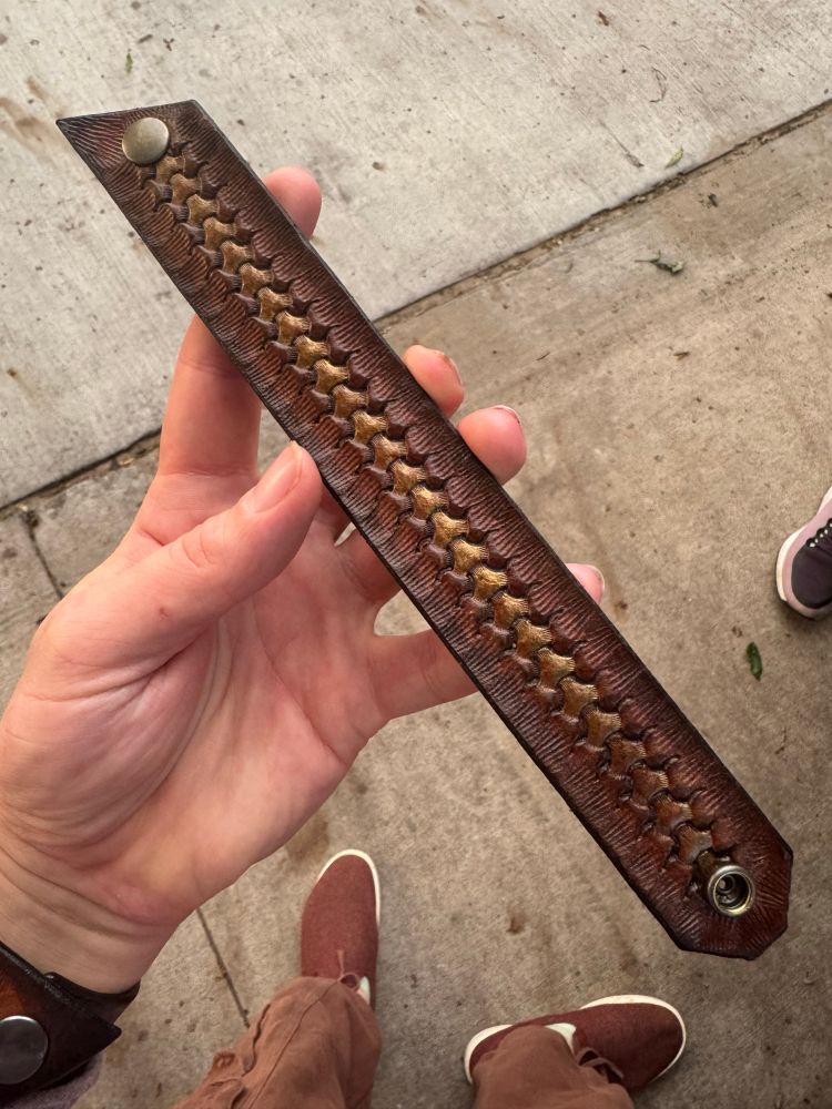 A handmade leather bracelet with a bronze stripe down the middle