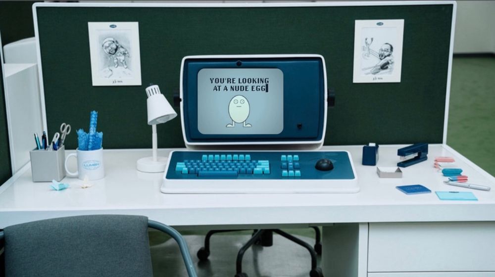 A screenshot of Dylan's desk from "Severance", except the monitor displays the nude egg win screen from the "I think you should leave" skit.