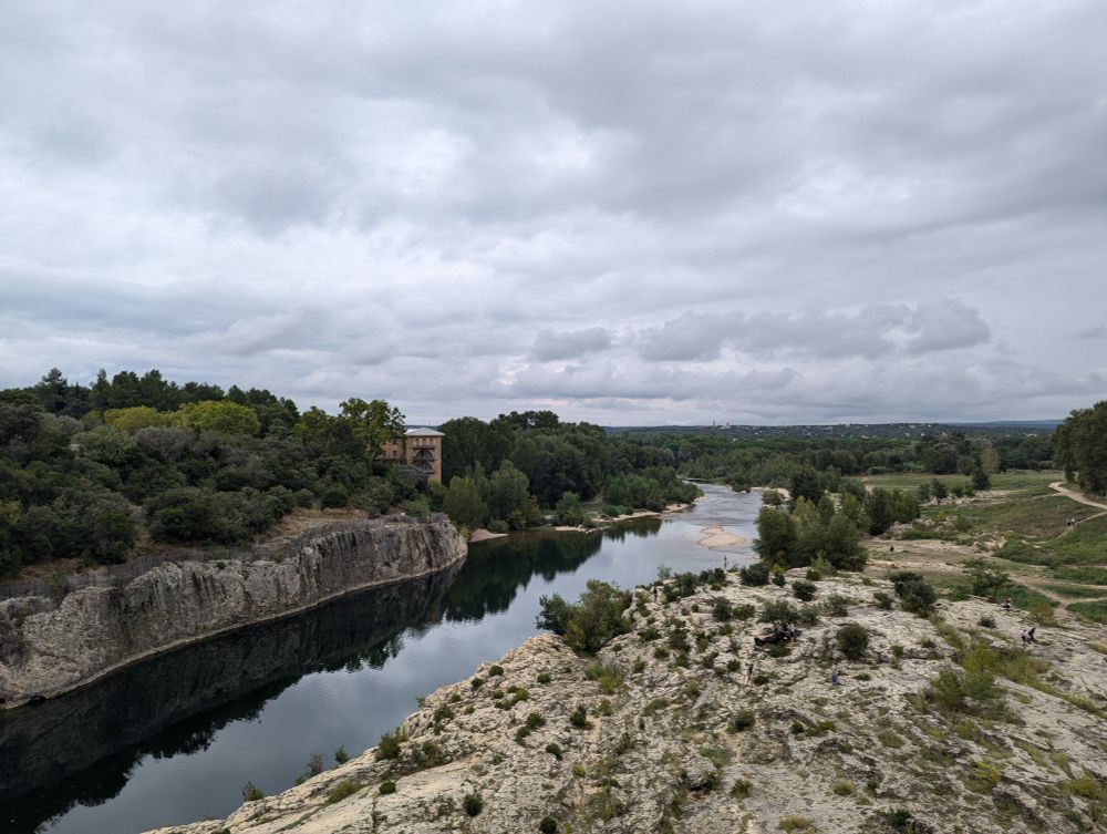 a view on the river taken from the bridge in the foreground with the Provence countryside in the background
