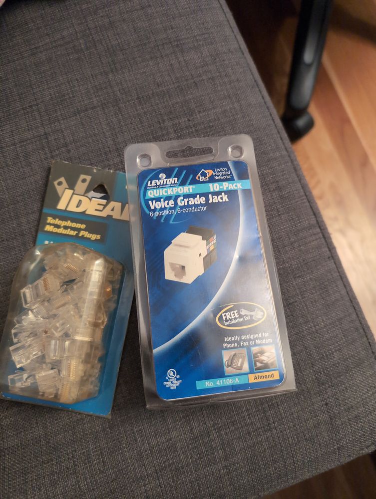 Overhead photo of a couple of blister packs of telephone modular wall jacks and plugs.