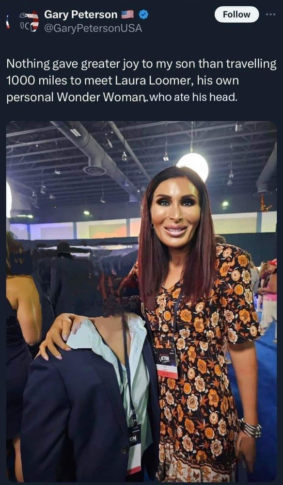 Laura Looney with her arm around the corpse of a child, who's head she has just eaten, and his muscles are still holding his headless body upright. Laura is smiling, clearly having enjoyed the snack. 