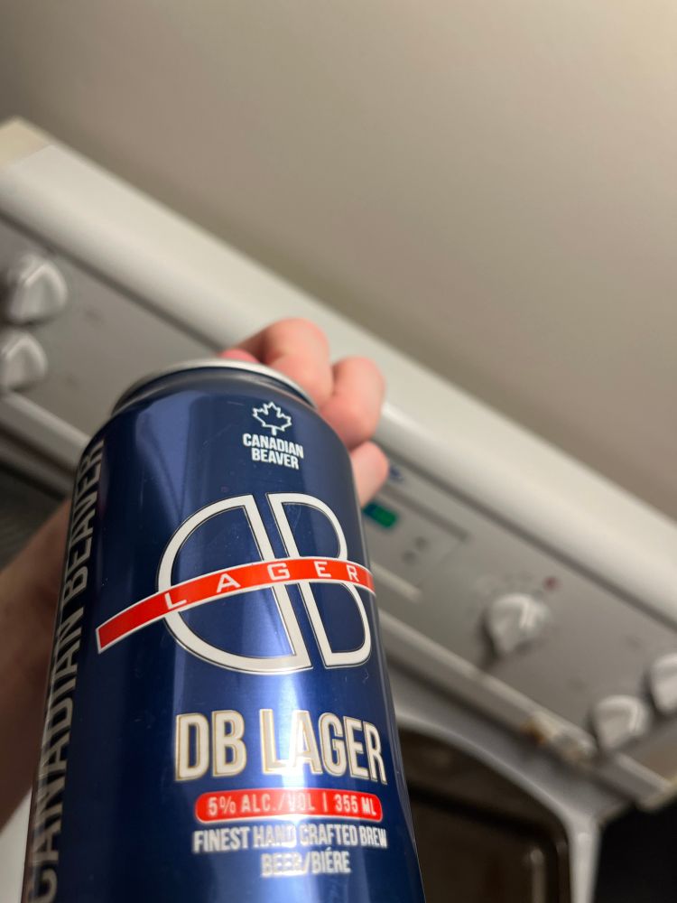 my left hand holding a can of DB Lager from Canadian Beaver