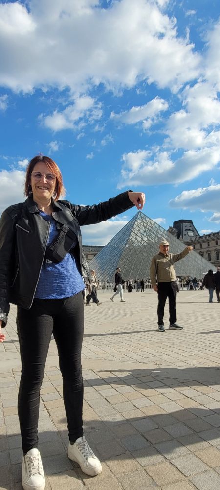Une femme qui tient la pyramide du Louvre 