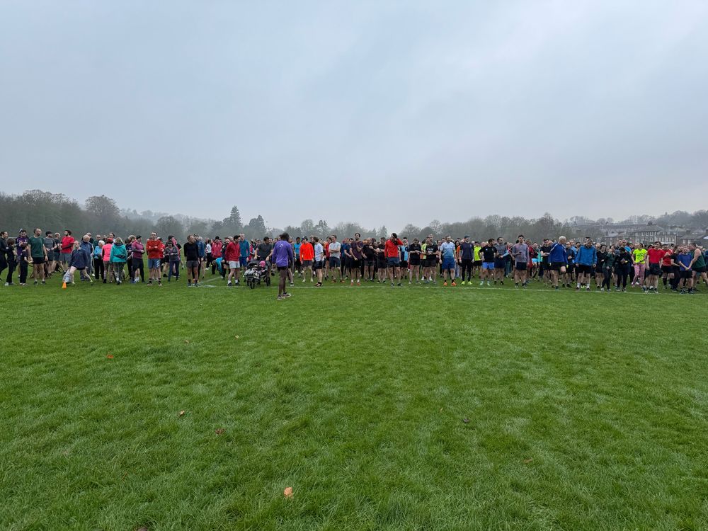 A large group of people in park lining up for parkrun