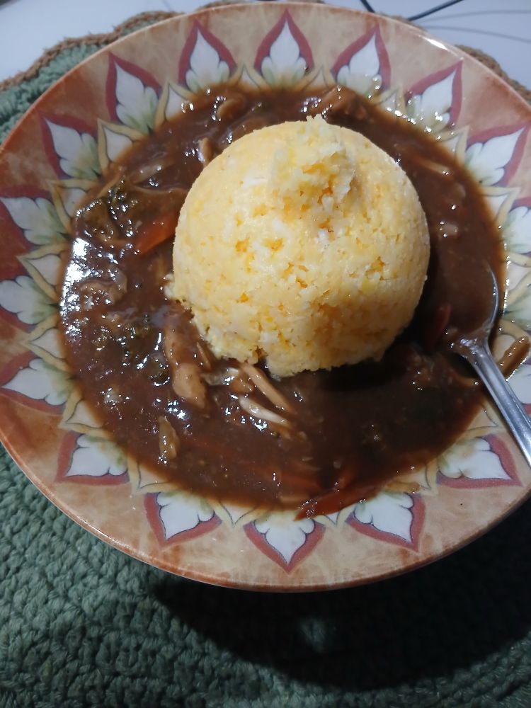 Foto de um prato. Nele, há restos de yakissoba, principalmente molho. No centro, há cuscuz em formato semiesferico com a base para baixo.