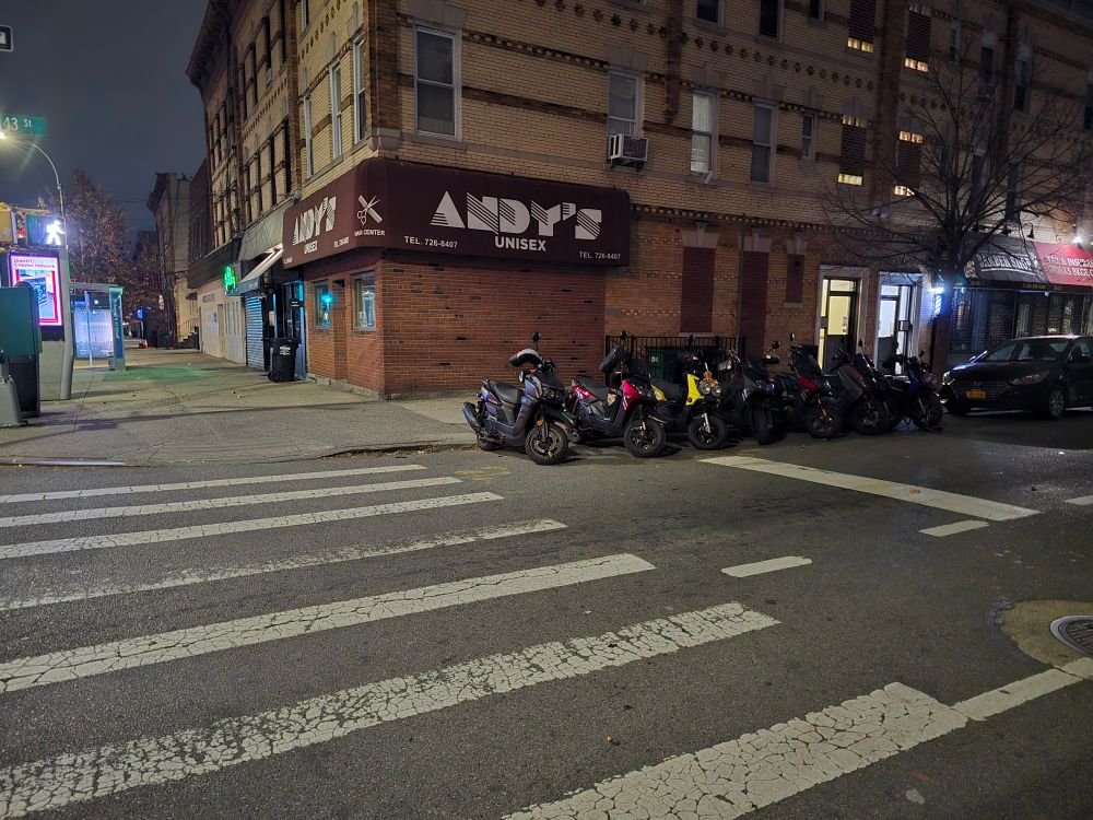 Motorbikes in a row before crosswalk. 