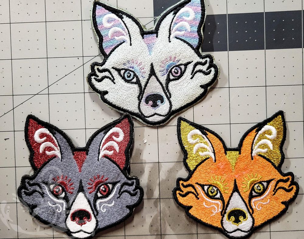 3 embroidered fox patches: gray with red metallic accents, orange with gold metallic accents, and iridescent white with blue and lilac variegated accents. 