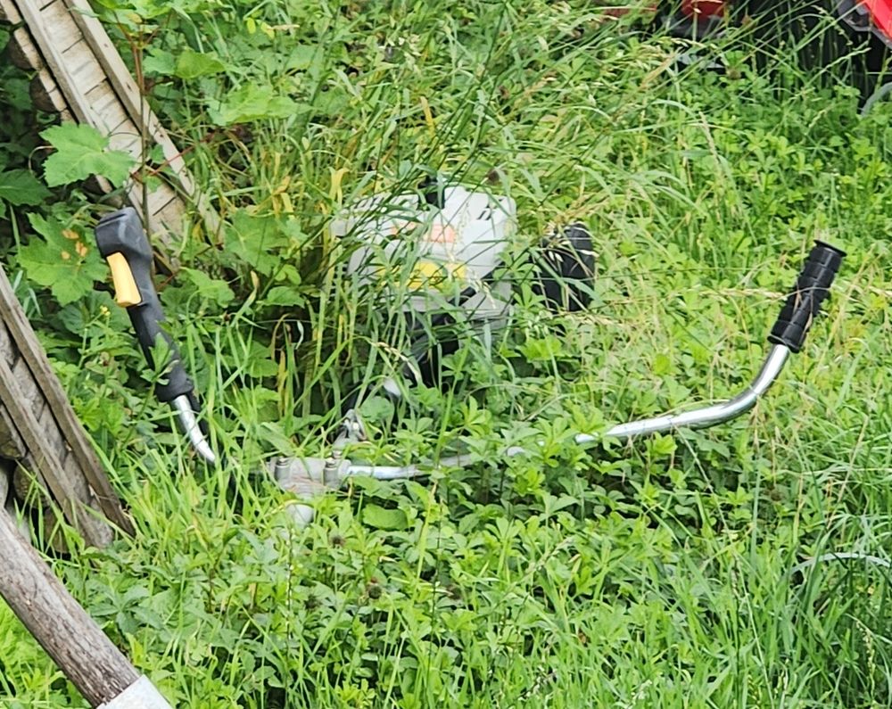Une débroussailleuse (abandonnée) enfoui dans l’herbe