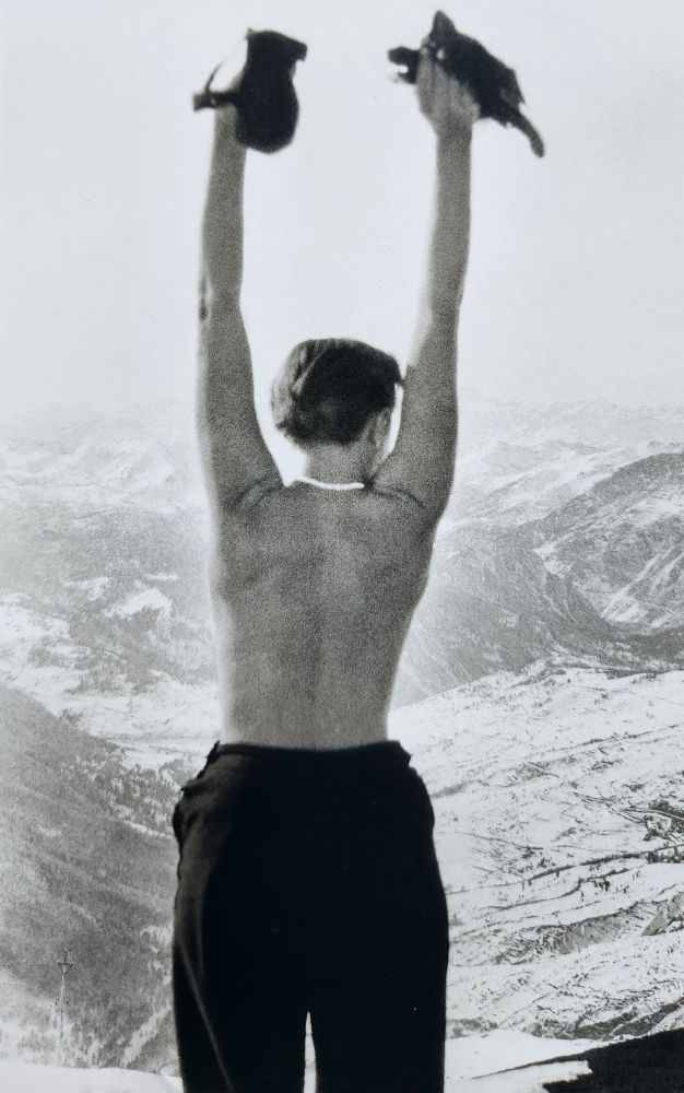 Photo N&B, une femme de dos torse nu les bras levés devant une vallée enneigée (Charlotte Perriand face à la vallée 1930)