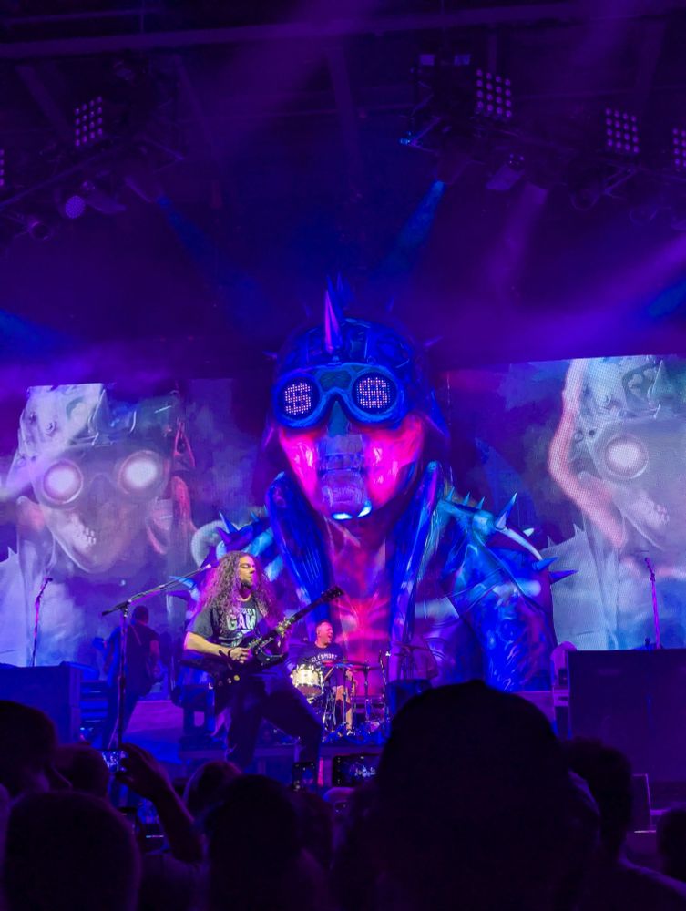 Blind side Sonny staring out from the dark. Claudio Sanchez plays guitar in the foreground 