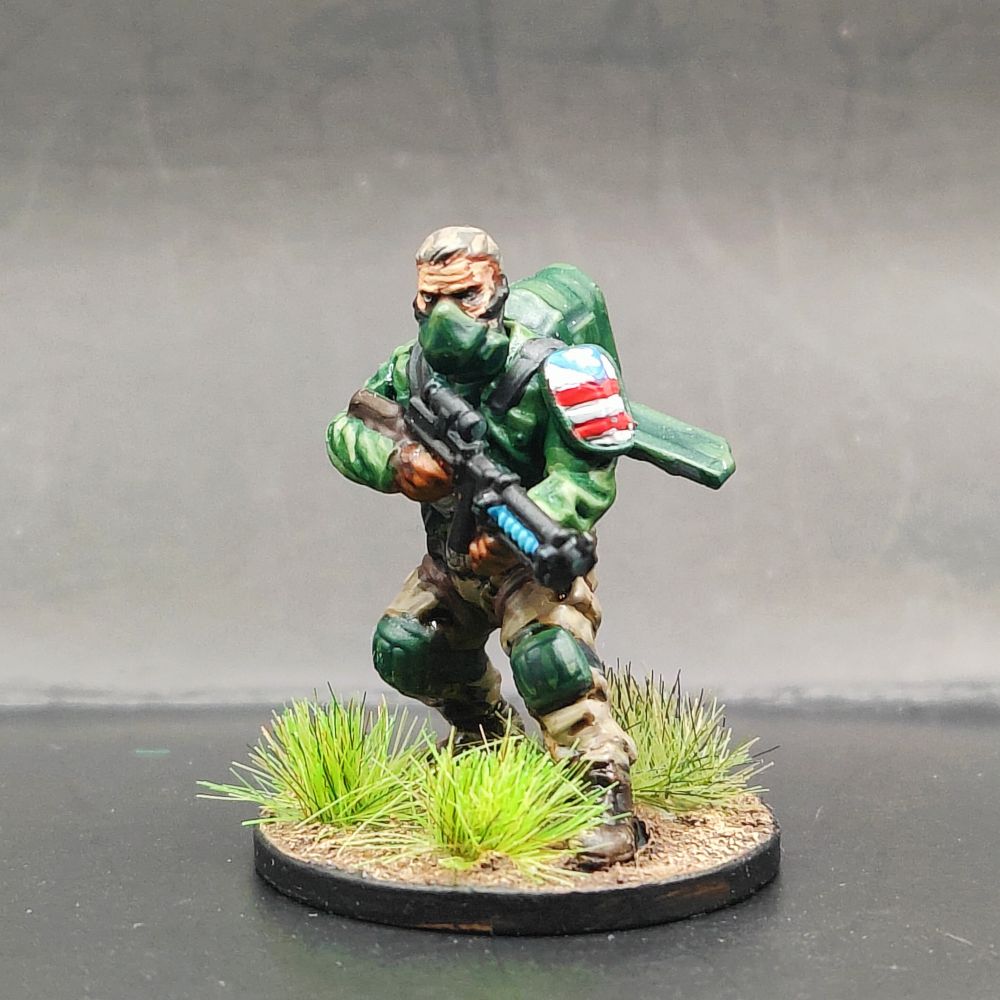 A weird war airborne soldier in a green jacket with khaki trousers and with the American flag on his shoulder pad