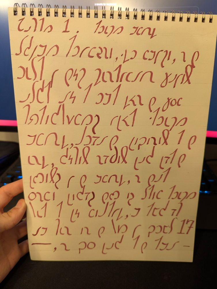 A sheet of paper with handwriting in the Shavian alphabet written with a calligraphy pen