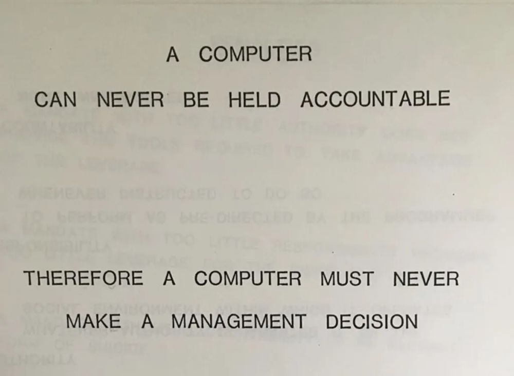A photograph of a slide from a presentation by IBM in 1979. It's black text on white paper and at the top it reads in block capitals, "A computer can enver be held accountable" and below it reads "Therefore a computer must never make a management decision".