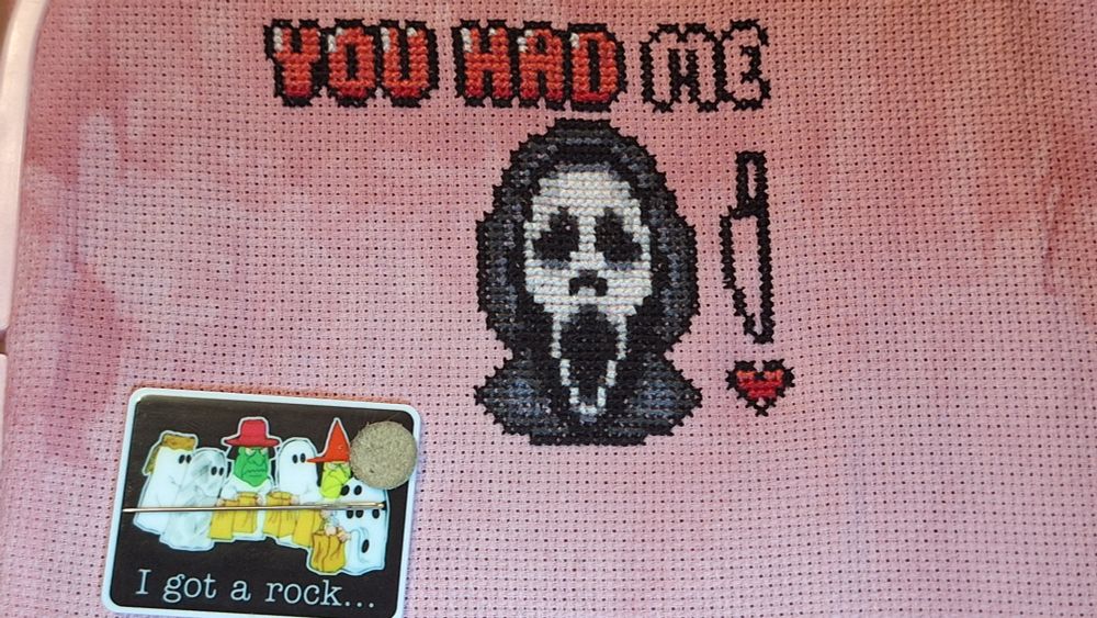 A cross stitch piece of ghostface from the movie Scream with the text "You had me" at the top and a knife and heart to the right side. Stitched on a 18 CT fiber on a whim Peony. 