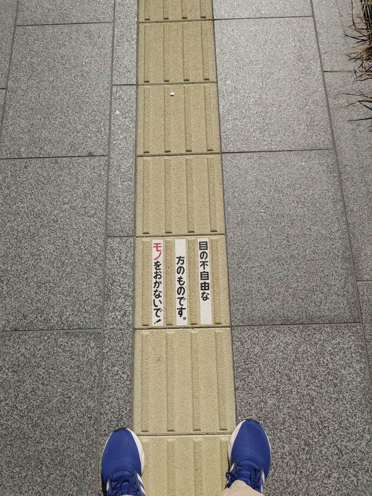 グラングリーン大阪 北館横の歩道にある点字ブロック
「目の不自由な方のものです。モノをおかないで！」と書いてある