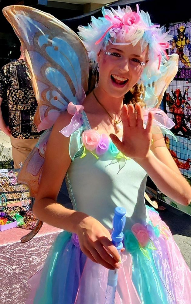 A 'fairy' entertainer waves to the crowd.